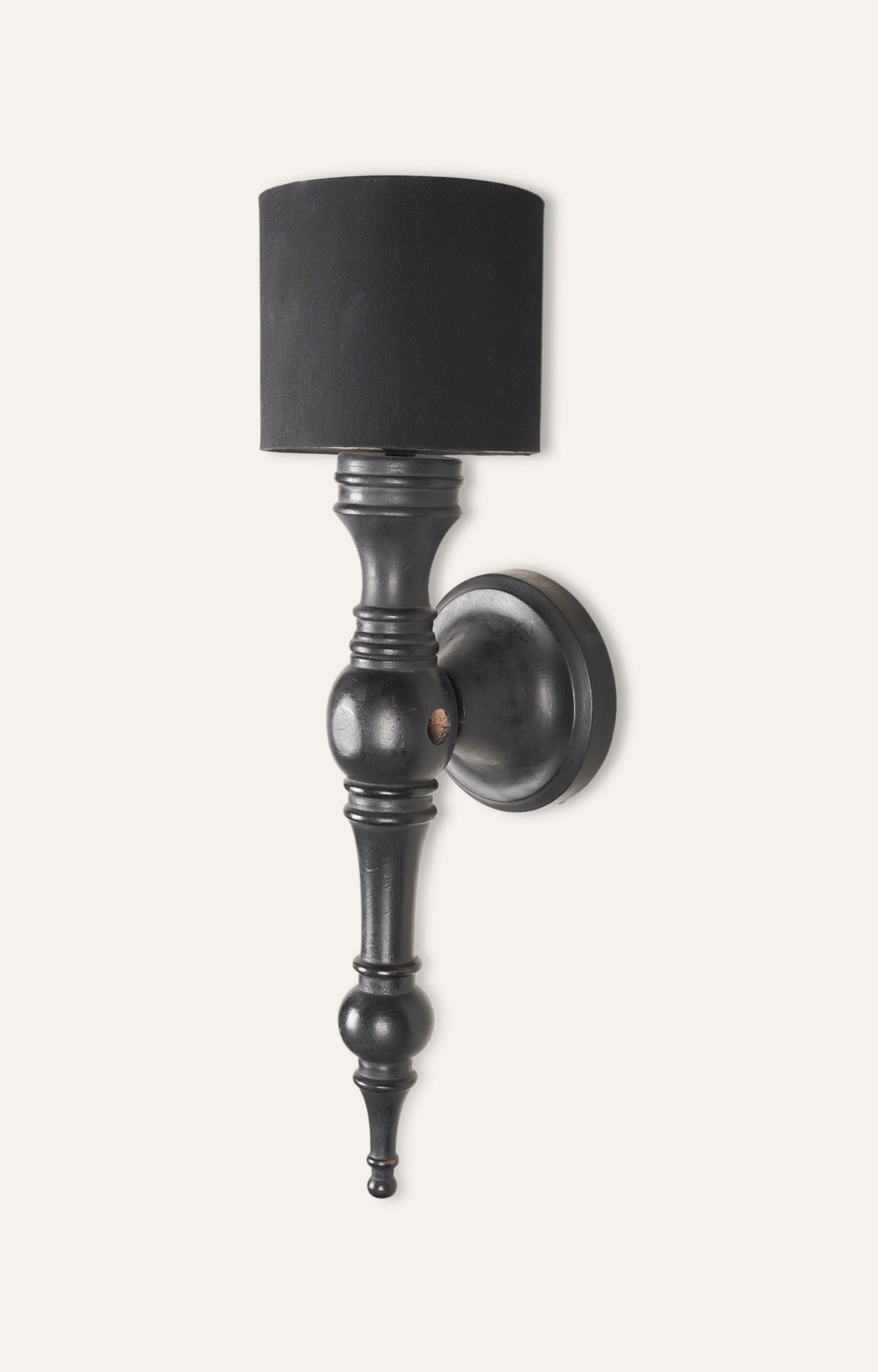 Black wooden wall sconce with cylindrical casement shade and LED bulb.