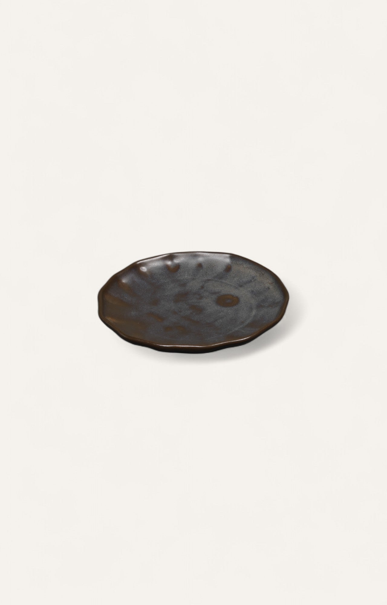 Charcoal-toned glazed ceramic plate with ripple-edge design