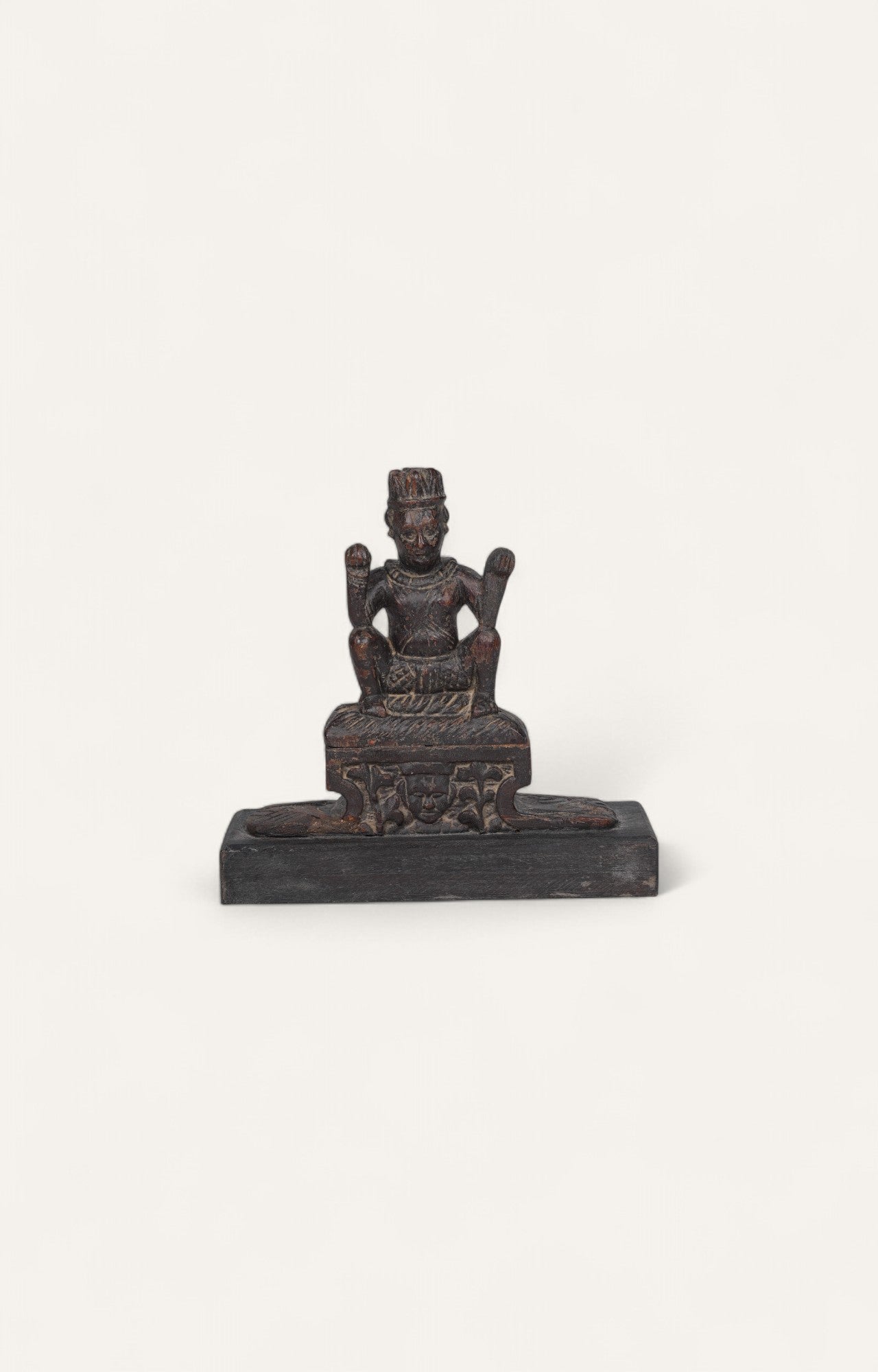Antique teak wood folk sculpture of a seated deity with aged surface and rustic character.