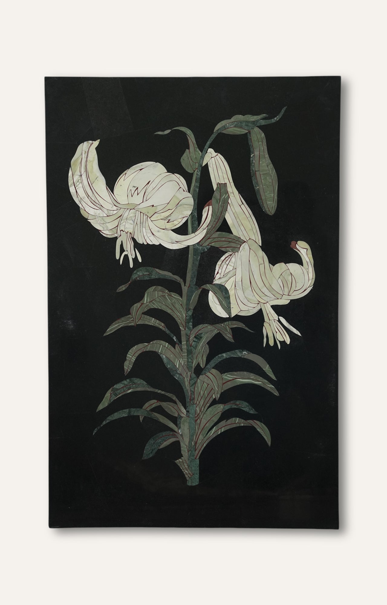 Lily flower inlay wall panel in black limestone with pale green and white detailing.
