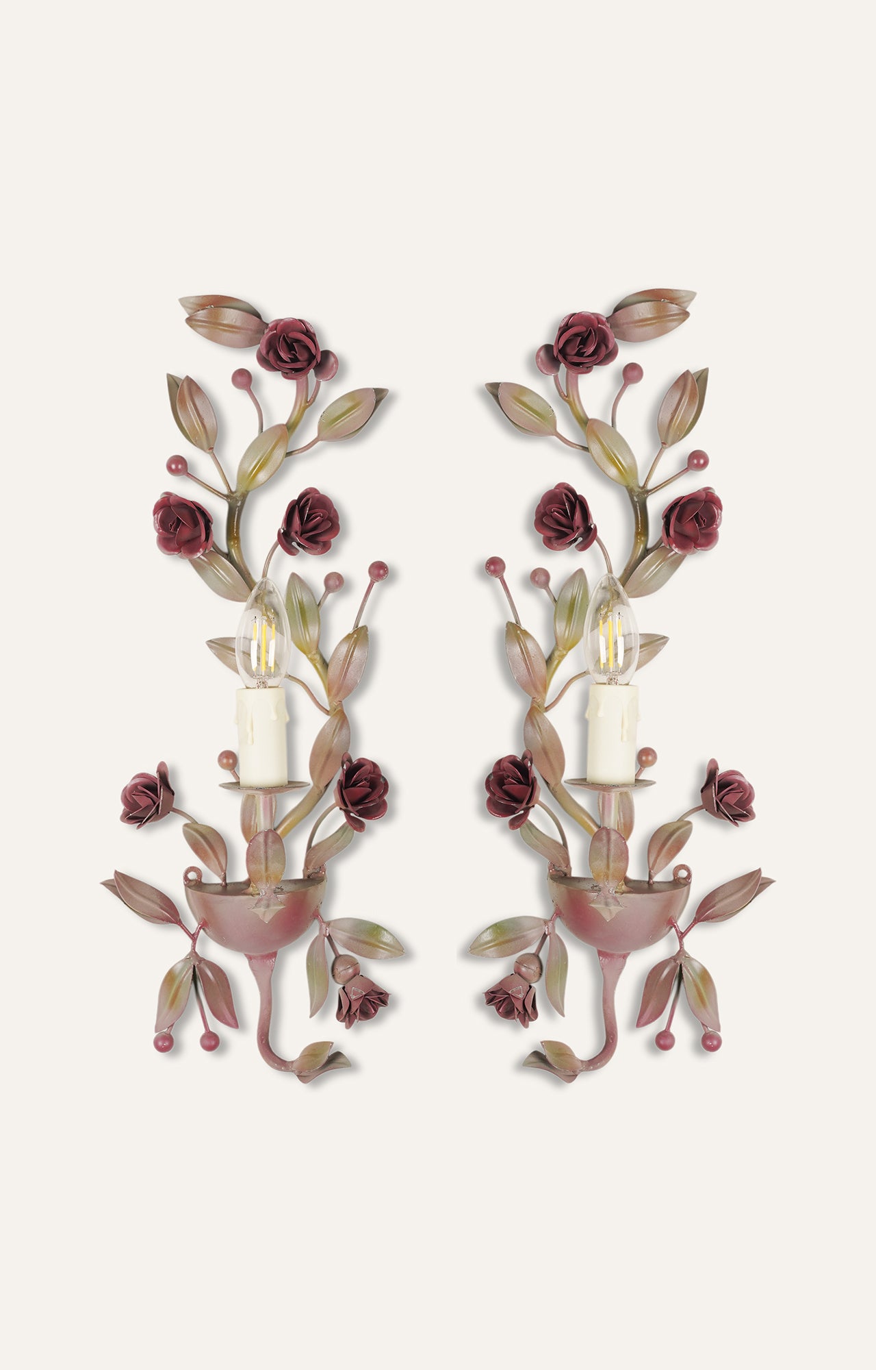 Floral wall sconce with powder pink painted metal and light attached.