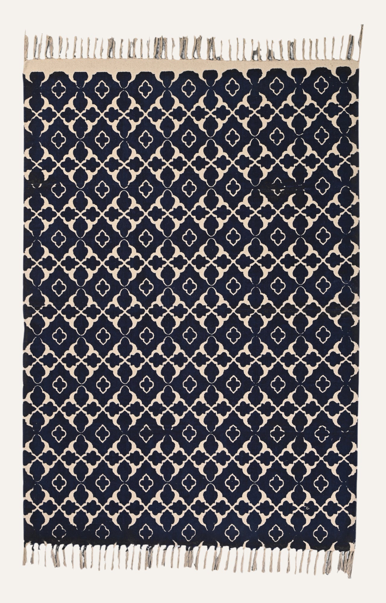  Indigo blue screen-printed cotton rug with symmetrical beige trellis pattern.