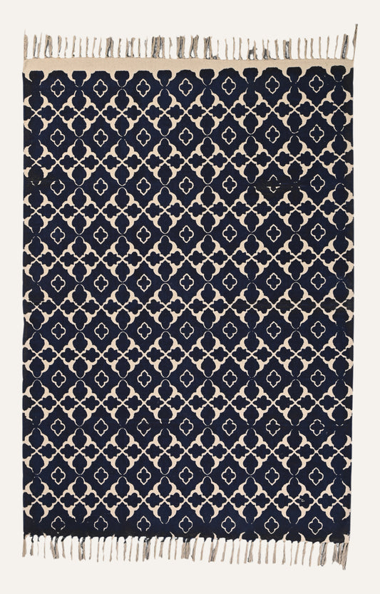  Indigo blue screen-printed cotton rug with symmetrical beige trellis pattern.