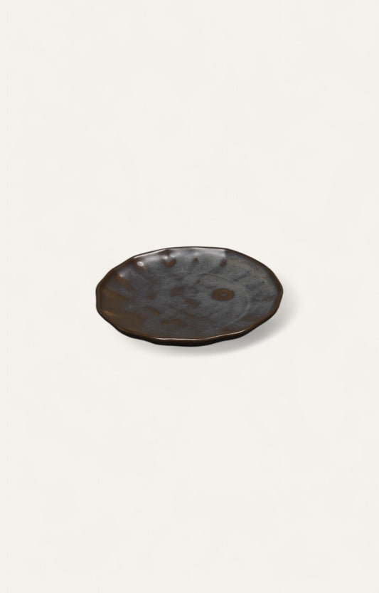 Charcoal-toned glazed ceramic plate with ripple-edge design
