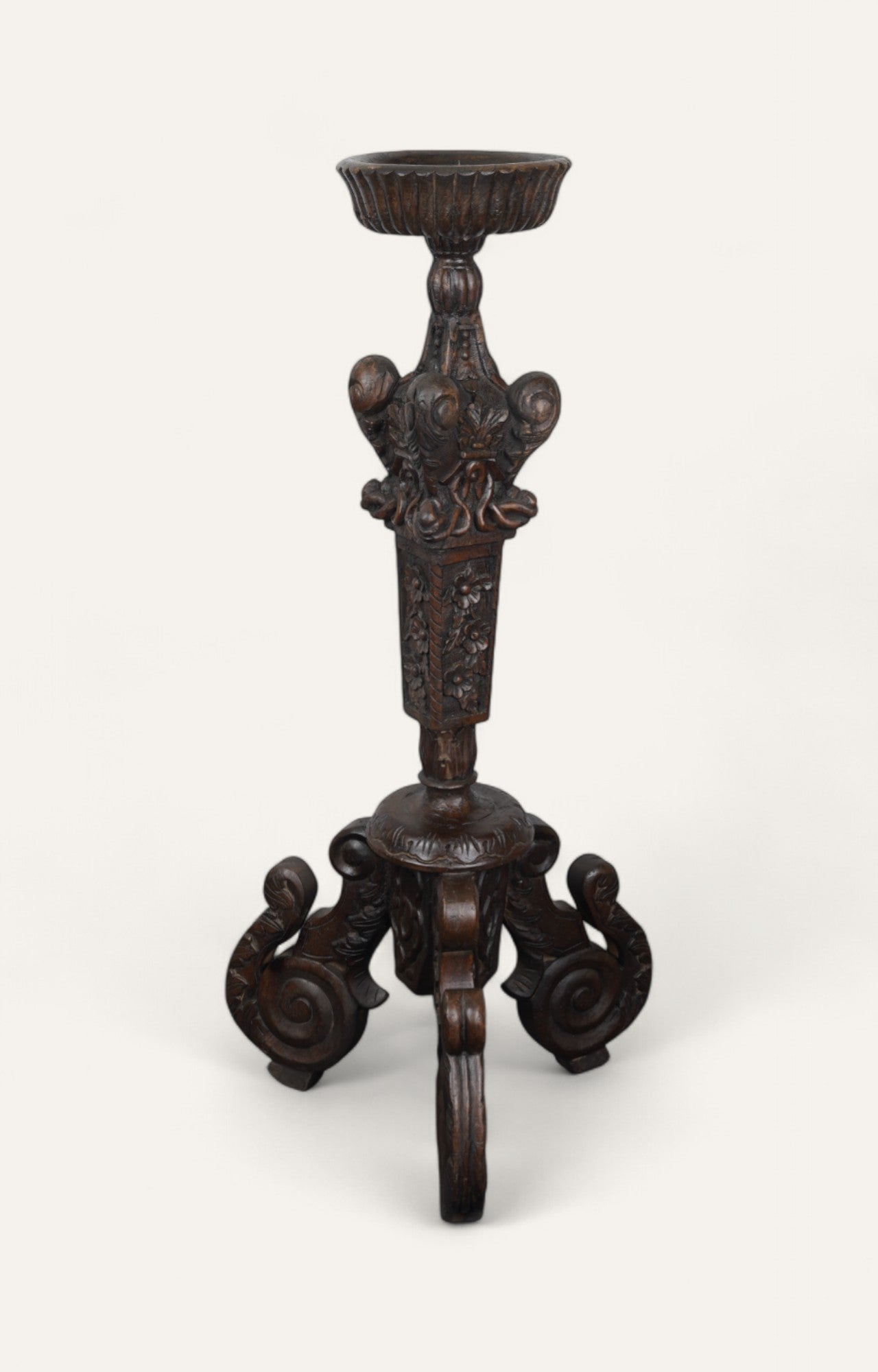 Large ornate wooden candle holder with tripod scroll base in dark finish
