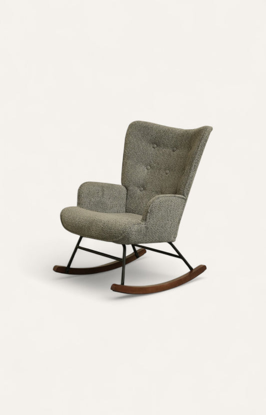 Rocking chair upholstered in soft grey boucle fabric with a light rubber wood frame and black iron legs.