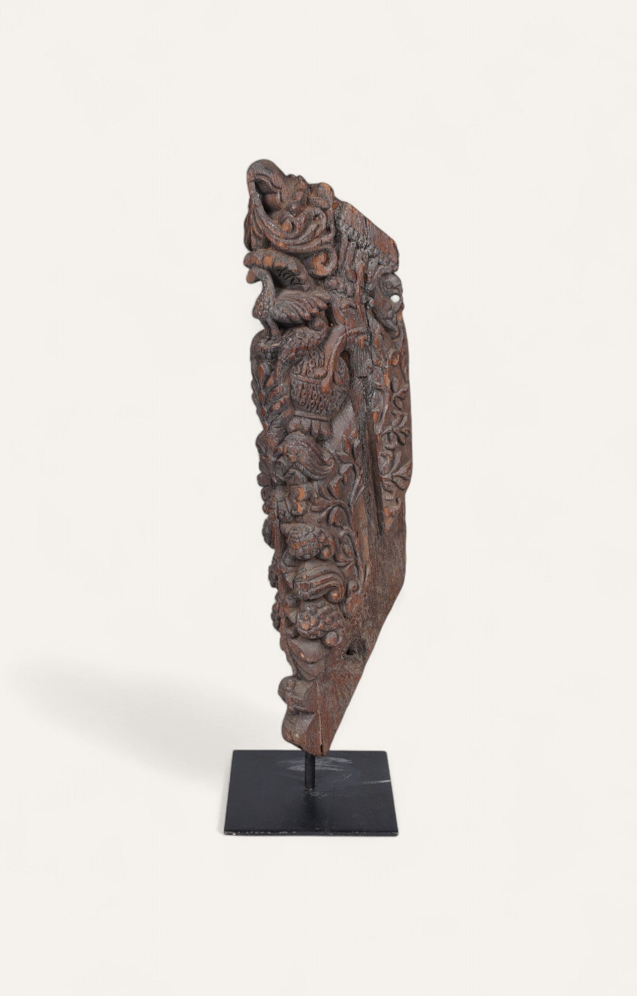 Teak wood carved architectural column fragment on black iron base
