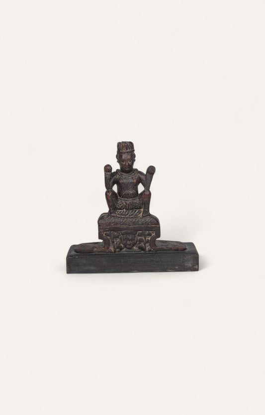 Antique teak wood folk sculpture of a seated deity with aged surface and rustic character.