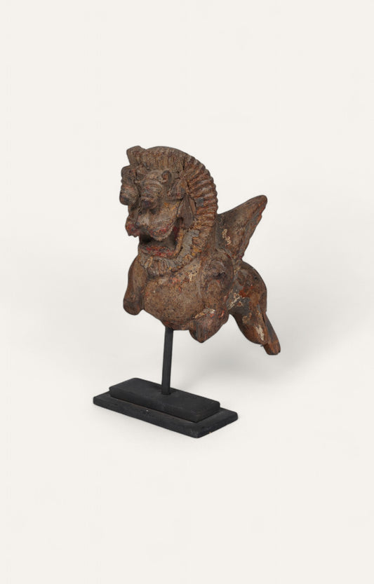 Distressed Tibetan carved figure on iron stand with red patina