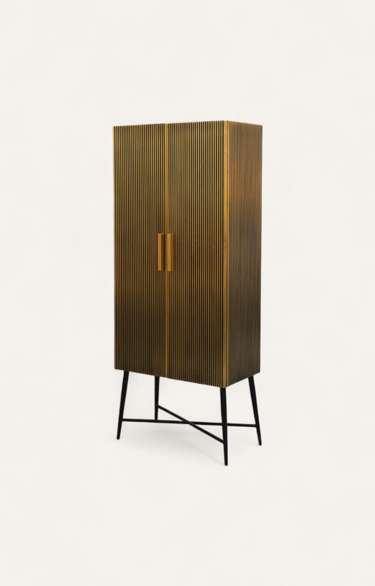 Tall brass wall cabinet with fluted texture and black iron legs