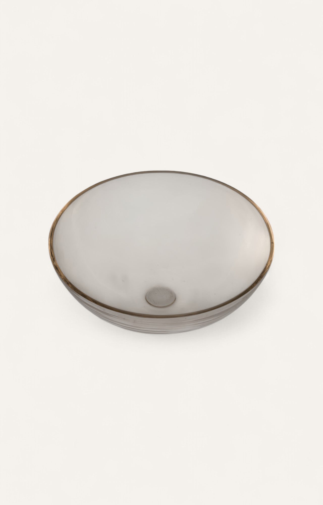 Clear glass fruit bowl with broad curved form and subtle gold rim.